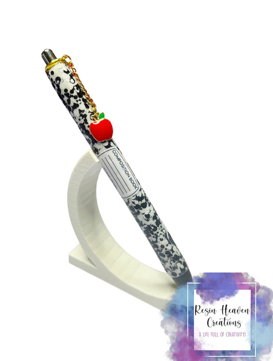 Composition notebook pen with charm.
